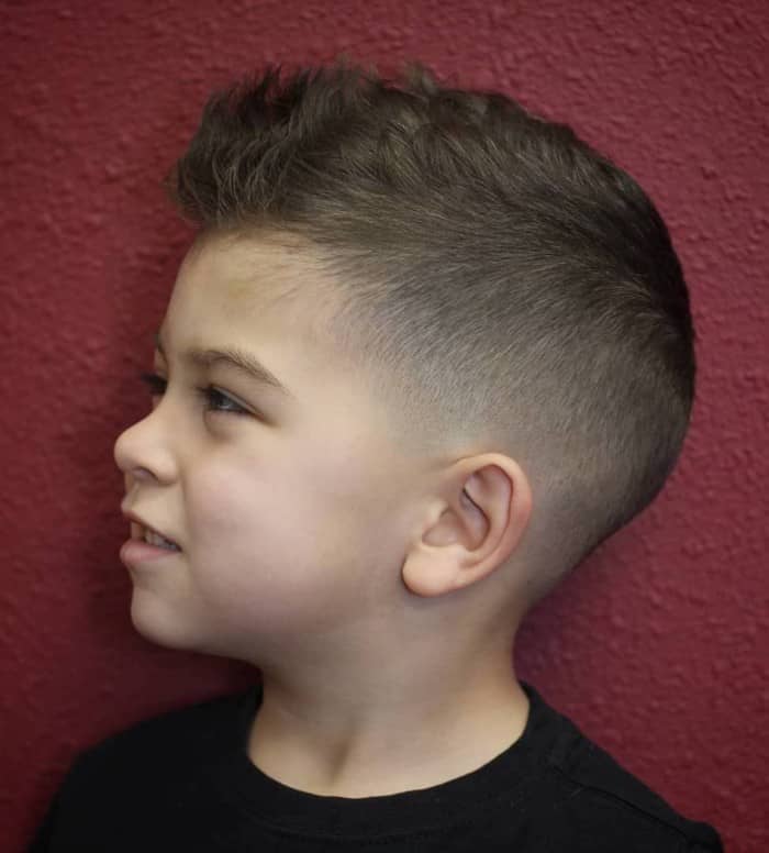 Das kleine Kind mit welligem Haar und Hinterschnitt